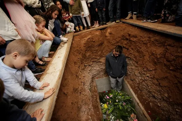A relative reacts during the burial of Rhonita Miller and her children Howard, Kristal, Titus, and Teana, who were killed by unknown assailants, in LeBaron, Chihuahua, Mexico on November 8, 2019. Members of breakaway Mormon communities that settled in Mexico decades ago, Miller and two other women and six children were ambushed in Sonora state on November 4, leading U.S. President Donald Trump to urge Mexico and the United States to “wage war” together on the drug cartels. (Photo by Jose Luis Gonzalez/Reuters)