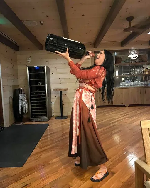 American singer-songwriter Katy Perry gets after it with a giant bottle of wine in the second decade of April 2022. (Photo by katyperry/Instagram)