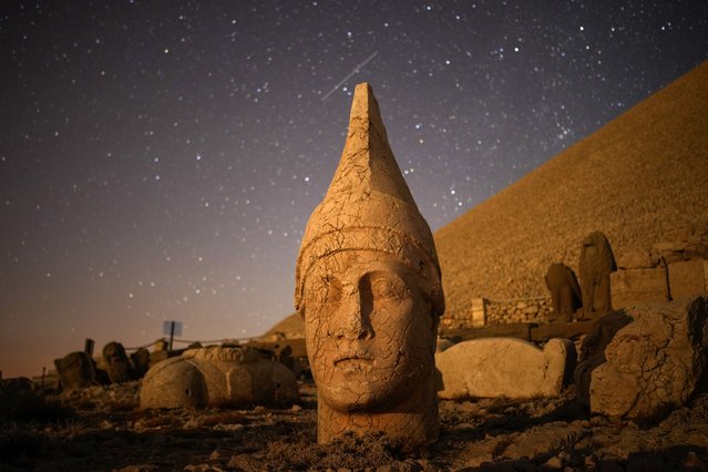 Ancient statues are seen during the Perseid meteor shower atop Mount Nemrut in southeastern Turkey, Sunday, August 11, 2024. Perched at an altitude of 2,150 meters (over 7,000 feet), the statues are part of a temple and tomb complex that King Antiochus I, of the ancient Commagene kingdom, built as a monument to himself. (Photo by Emrah Gurel/AP Photo)