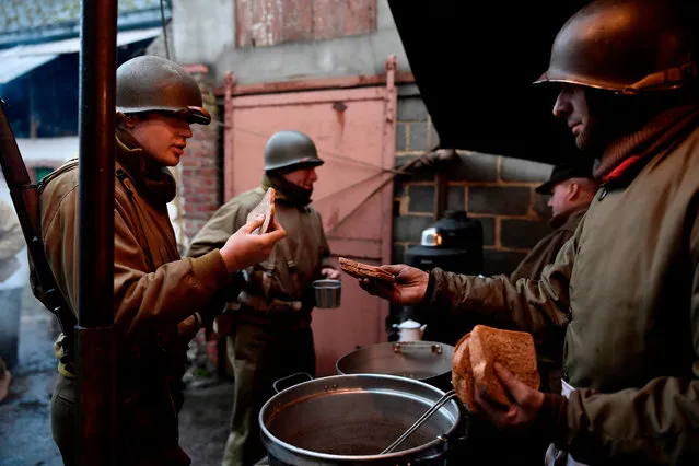 Actors wearing WWII US uniforms stand in a canteen as they take part in a historical re-enactment of the Battle of the Ardennes as part of commemorations marking the 75th anniversary of the WWII battle, on Decembre 15, 2019 in Hardigny. The battle, fought over the winter months of 1944 and 1945, was the last major Nazi offensive against the Allies in World War II. (Photo by John Thys/AFP Photo) 