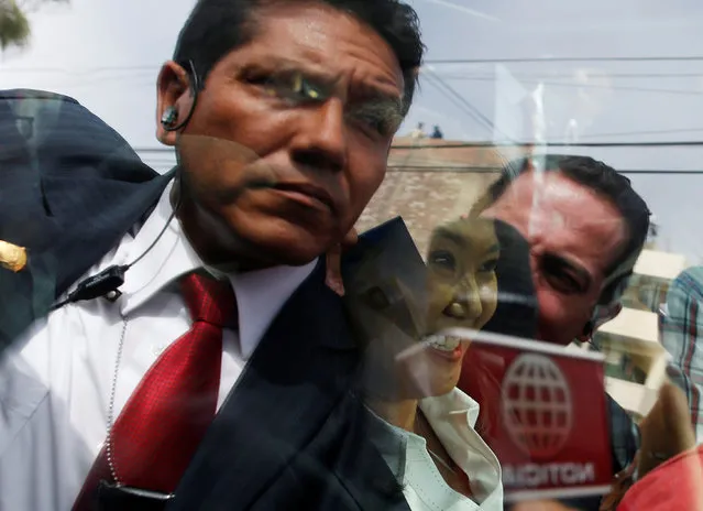 Peruvian presidential candidate Keiko Fujimori (C) sits inside a car as security personnel are seen reflected in the windows outside a polling station in Lima, Peru, June 5, 2016. (Photo by Janine Costa/Reuters)