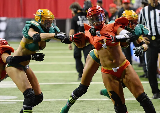 Danika Brace #8 of the Las Vegas Sin breaks tackles by Anna Heasman #13 and Laurie Gelis-Diaz #11 of the Green Bay Chill to score a touchdown during their game at the Thomas & Mack Center on May 15, 2014 in Las Vegas, Nevada. Las Vegas won 34-24. (Photo by Ethan Miller/Getty Images)