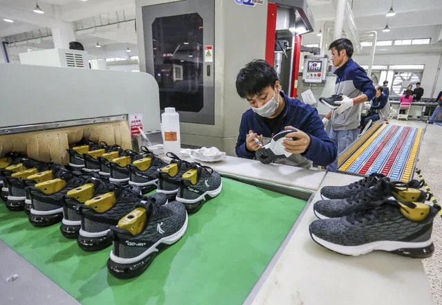 In this January 3, 2020, photo, workers make sneakers in a factory in Jinjiang city in southeastern China's Fujian province. China’s economic growth sank to a new multi-decade low of 6.1% in 2019 as consumer demand weakened and Beijing fought a trade war with Washington. Government data Friday, Jan. 17, showed growth was down from 2018’s 6.6%, already the lowest since 1990. Economic growth in the three months ending in December held steady at the previous quarter’s level of 6%. (Photo by Chinatopix via AP Photo)