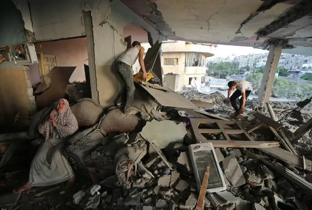 A Palestinian woman (L) cries inside her damaged house, which police said was targeted in an Israeli air strike, in Gaza City July 17, 2014. Israeli shelling killed four Palestinian boys on a Gaza beach on Wednesday, an incident the military called tragic, and Israel and Hamas said they would cease attacks for five hours on Thursday for a humanitarian truce requested by the United Nations. (Photo by Mohammed Salem/Reuters)