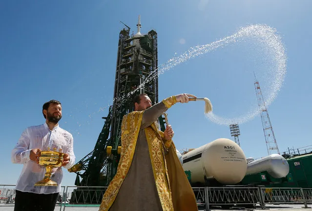An Orthodox priest conducts a blessing in front of the Soyuz MS-05 spacecraft set on the launchpad ahead of its upcoming launch, at the Baikonur Cosmodrome in Kazakhstan July 27, 2017. (Photo by Shamil Zhumatov/Reuters)
