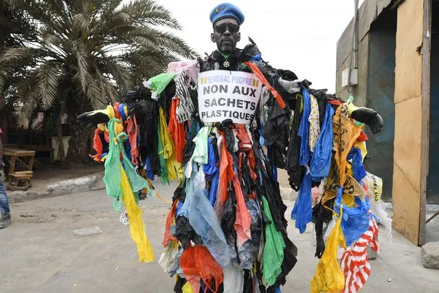 Senegalese activist Modou Fall, called the plastic man, president of the association Senegal Propre (Clean Senegal), is seen on June 15, 2022, at the entrance of Pikine, a suburb in Dakar during the departure of the tour of Senegal on foot to sensitize Senegalese of the harm of plastic bags for the environment. (Photo by Seyllou/AFP Photo)