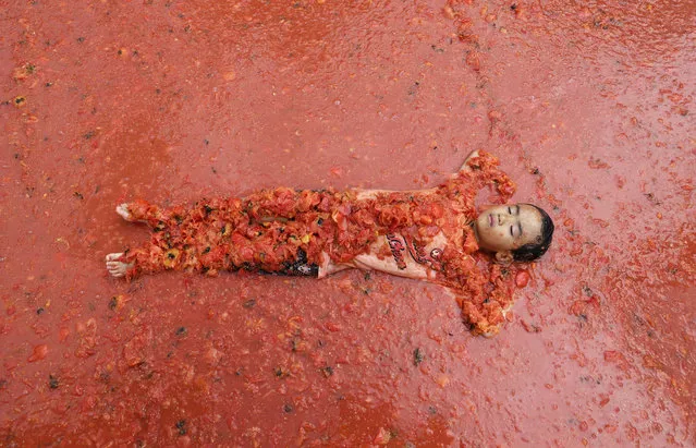 A boy lies in a pool of tomatoes during the 2017 Tomato Festival in Hwacheon, South Korea, Saturday, August 5, 2017. The festival runs from Aug. 4 to Aug. 7. (Photo by Ahn Young-joon/AP Photo)