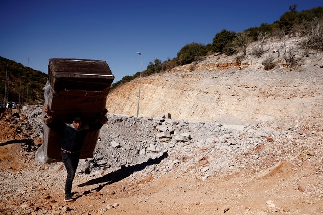 A boy carries his belongings while crossing from Lebanon into Syria on foot at the Masnaa border crossing, after an Israeli strike, as he and others flee the ongoing hostilities between Hezbollah and Israeli forces, in Al Masnaa, Lebanon on October 27, 2024. (Photo by Yara Nardi/Reuters)