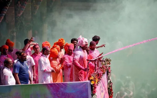 A Hindu priest sprays coloured water at the devotees on a temple premises during Holi celebrations in Ahmedabad, India, March 10, 2020. (Photo by Amit Dave/Reuters)