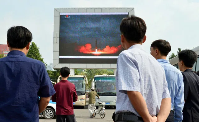 North Koreans watch a news report showing North Korea's Hwasong-12 intermediate-range ballistic missile launch on electronic screen at Pyongyang station in Pyongyang, North Korea, in this photo taken by Kyodo August 30, 2017. (Photo by Reuters/Kyodo News)