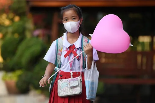 A girl arrives to a school wearing a protective face mask on Valentine's Day in Ayutthaya, outside Bangkok, Thailand on February 14, 2020. (Photo by Chalinee Thirasupa/Reuters)