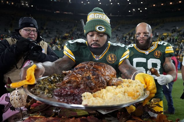 Green Bay Packers running back Josh Jacobs (8) holds a plate of turkey after an NFL football game against the Miami Dolphins Thursday, November 28, 2024, in Green Bay, Wis. (Photo by Morry Gash/AP Photo)