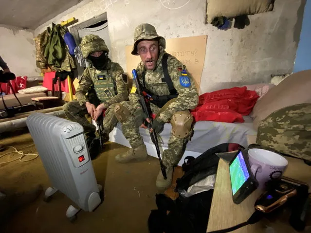 Members of the Ukrainian Territorial Defense Forces watch the FIFA World Cup 2022 qualification playoff semi-final soccer match between Scotland and Ukraine on a mobile phone in a shelter, as Russia's attack on Ukraine continues, in Kharkiv, Ukraine on June 1, 2022. (Photo by Vitalii Hnidyi/Reuters)
