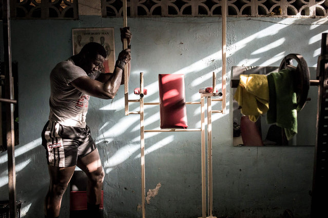A Senegalese wrestler rests in a gym that is specially opened for him in Dakar on April 15, 2020. Professional Senegalese wrestlers would usually train in specialised gyms but due to the COVID-19 precautions they now train alone in smaller gyms, in small teams on the beach or at their house. (Photo by John Wessels/AFP Photo)
