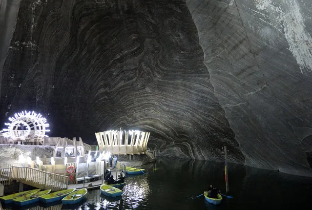 A picture shows general view of a chamber with an underground lake and boats inside Salina Turda salt mine, Romania, October 10, 2017. Closed for operation in 1932, the mine was opened to the public in 1992. In 2010 it was transformed into a themed park, offering different attractions such as boat tours in an underground lake, an amphitheatre, a carousel, as well as sports activities venues and recreation areas. (Photo by Stoyan Nenov/Reuters)