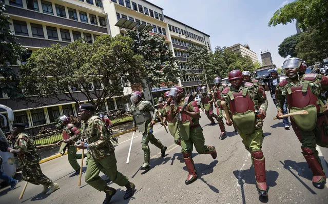 Kenyan riot police firing tear gas charge towards a small group of opposition supporters protesting over the upcoming elections in downtown Nairobi, Kenya, Monday, October 16, 2017. (Photo by Ben Curtis/AP Photo)