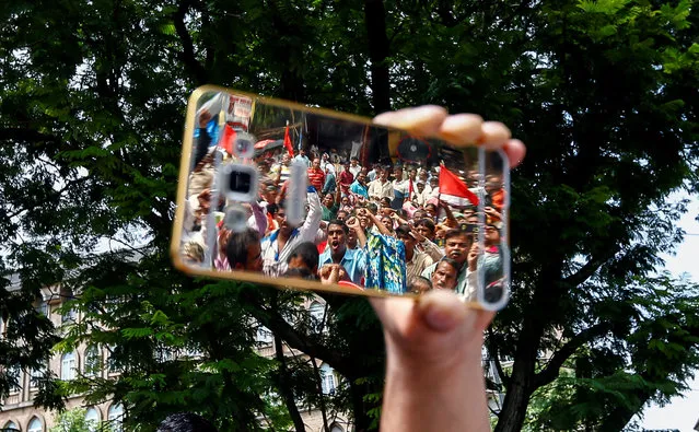 People are reflected on a phone as they attend a protest against what they say are attacks on India's low-caste Dalit community in Mumbai, India, August 12, 2016. (Photo by Danish Siddiqui/Reuters)