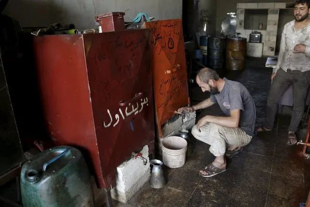 A fuel vendor fills a container with locally distilled fuel in Maarat Al-Nouman, south of Idlib September 17, 2015. Picture taken September 17, 2015. (Photo by Khalil Ashawi/Reuters)