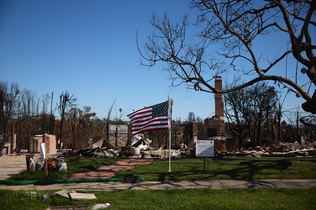 A US flag blows in the wind on a property destroyed by the Palisades wildfire in the Pacific Palisades neighborhood Los Angeles, California, USA, 18 March 2025. The Palisades Fire broke out 10 weeks ago today, destroying over 6,500 structures and 23,000 acres. (Photo by Allison Dinner/EPA)