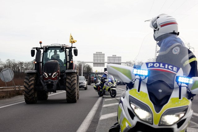 French farmers use their tractors during a go-slow operation near Roissy Charles-de-Gaulle airport as they protest over price pressures, taxes and green regulation, grievances shared by farmers across Europe, in Compans, near Paris, France on January 27, 2024. (Photo by Benoit Tessier/Reuters)
