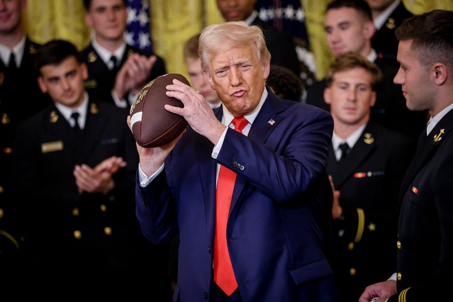 U.S. President Donald Trump, accompanied by Navy Midshipmen co-captain Linebacker Colin Ramos (R), holds up a football presented to Trumpduring a presentation ceremony for the Commander-in-Chief Trophy to the Navy Midshipmen football team in the East Room of the White House April 15, 2025 in Washington, DC. The Commander-in-Chief Trophy is awarded to the winner of the American college football series among the teams of the U.S. Military Academy (Army Black Knights), the U.S. Naval Academy (Navy Midshipmen), and the U.S. Air Force Academy (Air Force Falcons). (Photo by Win McNamee/Getty Images)