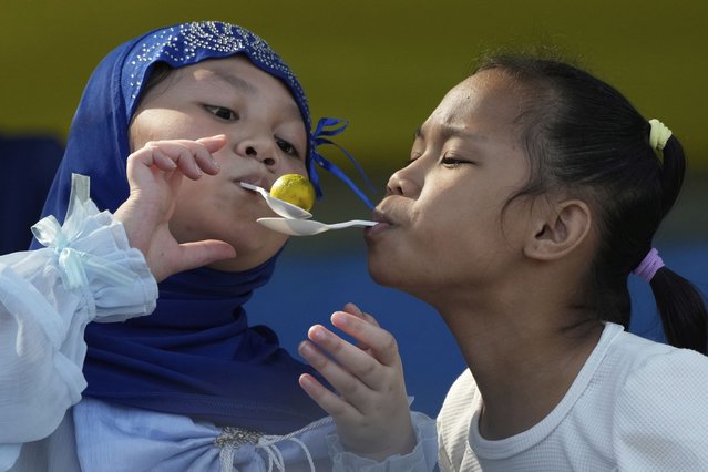 Muslim girls transfer Philippine lime using plastic spoons during a game as they celebrate Eid al-Fitr at a park in Quezon City, Philippines Monday, March 31, 2025. (Photo by Aaron Favila/AP Photo)