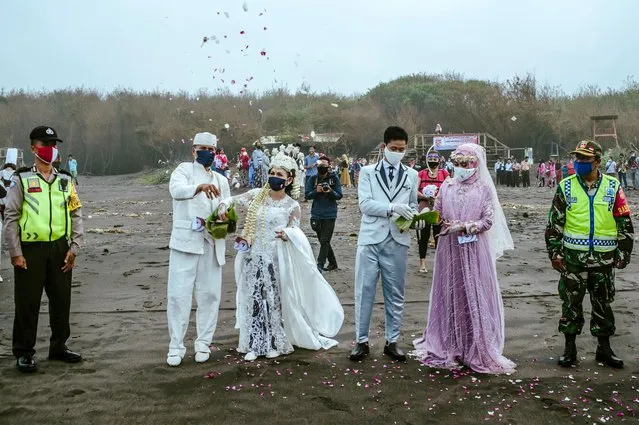 Brides and grooms take part in a mass wedding attended by 75 couples to commemorate the upcoming Indonesian Independence Day on August 17, at a field in Bantul, Yogyakarta on August 12, 2020. (Photo by Agung Supriyanto/AFP Photo)