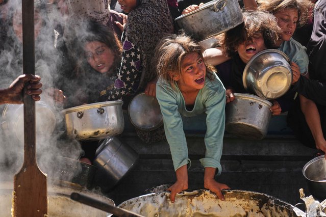 Palestinians struggle to get donated food at a community kitchen in Khan Younis, Gaza Strip, Friday, May 16, 2025. (Photo by Abdel Kareem Hana/AP Photo)