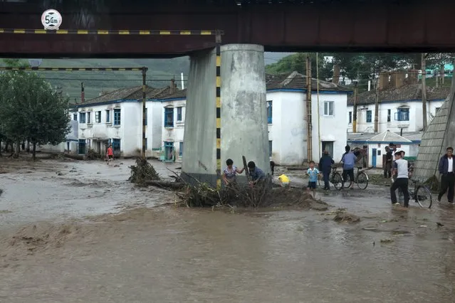 Residents attempt to clear flood debris from under a bridge in the city of Rajin in North Korea in this August 22, 2015 picture taken by a recent visitor. Heavy rain in North Korea killed 40 people, stranded thousands in flash floods and caused “massive” damage on the weekend, the International Federation of the Red Cross and North Korean media said. (Photo by Reuters/Stringer)