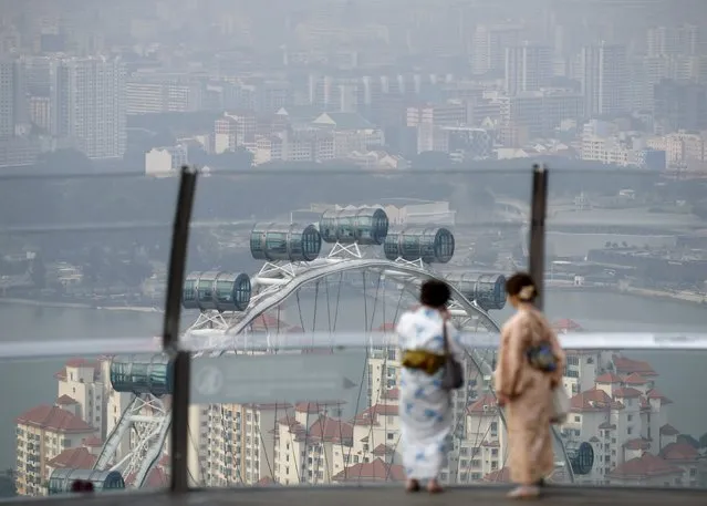 Women wearing kimonos look at the Singapore Flyer near the central business district in Singapore in this August 21, 2015 file photo. Singapore is expected to release GDP data this week. (Photo by Edgar Su/Reuters)