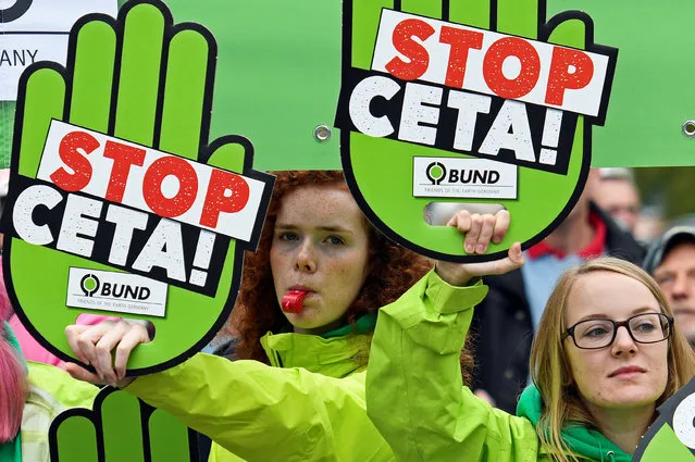 Consumer rights activists hold banners to protest against the Comprehensive Economic and Trade Agreement (CETA) during a meeting of Germany's Social Democrats (SPD), which are expected to narrowly vote in favour of a trade deal between the European Union and Canada in Wolfsburg, Germany, September 19, 2016. (Photo by Fabian Bimmer/Reuters)