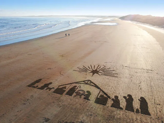 Heavenly drone pictures capture a giant beach nativity scene perfectly illuminated by a stunning sunset onto the sand at Beadnell Bay in Northumberland, England on December 14, 2022. (Photo by South West News Service)