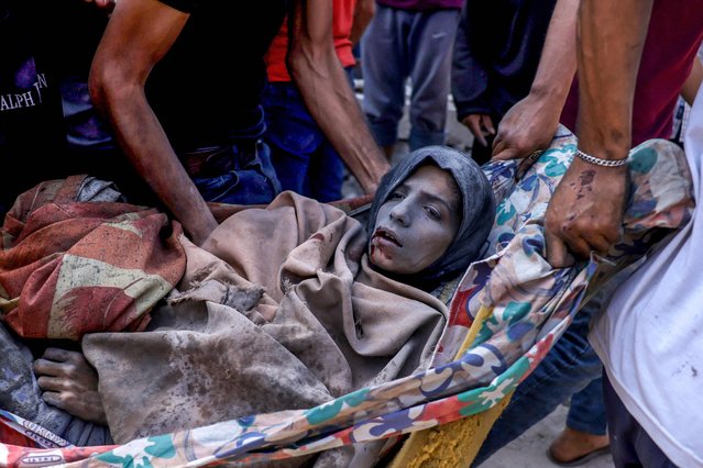 An injured Palestinian woman is carried after being pulled from the rubble of the Shaheen family home, that was targeted in an Israeli strike in the Saftawi neighbourhood, west of Jabalia, in the northern Gaza Strip on June 9, 2025. (Photo by Bashar Taleb/AFP Photo)