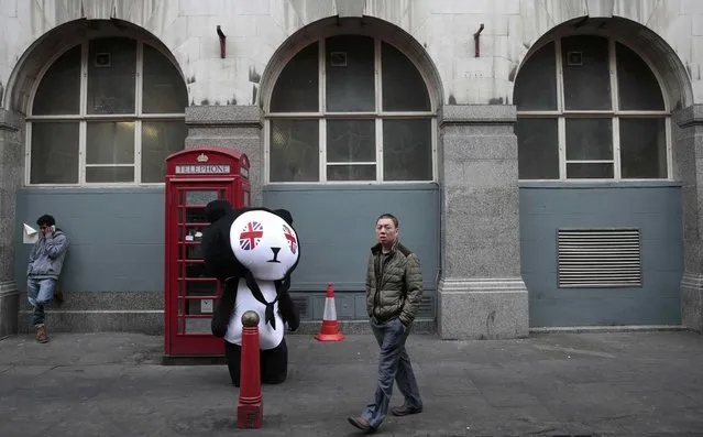 A man walks past a person wearing a panda costume on Gerrard Street in London's Chinatown, Britain October 19, 2015. Chinese President Xi Jinping arrives in Britain on Monday for a state visit at the invitation of Queen Elizabeth II, the first state visit to the United Kingdom by a Chinese leader since 2005. (Photo by Suzanne Plunkett/Reuters)