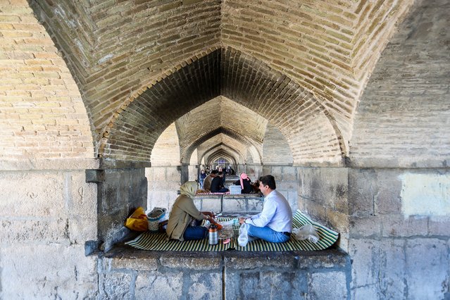 People gather for a picnic under the Si-o-Se Pol Bridge in Iran's central city of Isfahan on April 19, 2024. World leaders appealed for calm on April 19 after reported Israeli retaliation against Iran added to months of tense spillover from the war in Gaza, with Iranian state media reporting explosions in the central province of Isfahan. (Photo by Rasoul Shojaei/IRNA via AFP Photo)