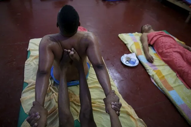 An inmate conducts an Ayurvedic massage on a fellow prisoner as part of the ACUDA programme at a complex of ten prisons in Porto Velho, Rondonia State, Brazil, August 27, 2015. Ayurveda is an ancient Hindu system of holistic healing. The massage is taught to the prisoners to help them understand the human body and engender a greater sense of compassion for others, according to ACUDA. (Photo by Nacho Doce/Reuters)