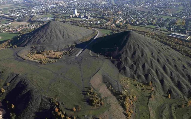 An aerial view shows the 11/19 pit and twin slag heaps at the former coal mine site in Loos-en-Gohelle, northern France, November 1, 2015. Loos-en-Gohelle, a town of 7000 inhabitants in the North of France, marked by the closure of coal mines in 1970, has demonstrated a successful transition from coal to a green economy. (Photo by Pascal Rossignol/Reuters)