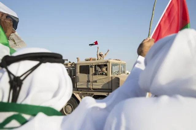 A member of the United Arab Emirates armed forces waves a UAE flag as the first batch of UAE military personnel returns from Yemen in Abu Dhabi, November 7, 2015. (Photo by Reuters/United Arab Emirates News Agency WAM)