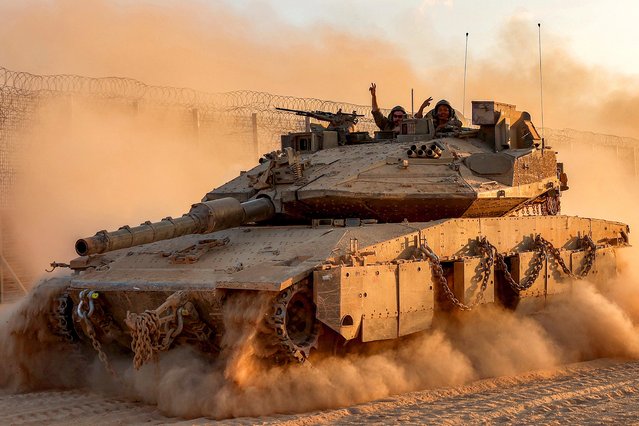 Israeli army soldiers gesture from the turret of a Merkava main battle tank moving at a position along the border fence with the Gaza Strip in southern Israel on September 12, 2025. Israel's military said on September 9 that it will act with “great force” in Gaza City and told residents to leave as it stepped up a deadly assault on the Palestinian territory's largest urban centre. (Photo by Jack Guez/AFP Photo)
