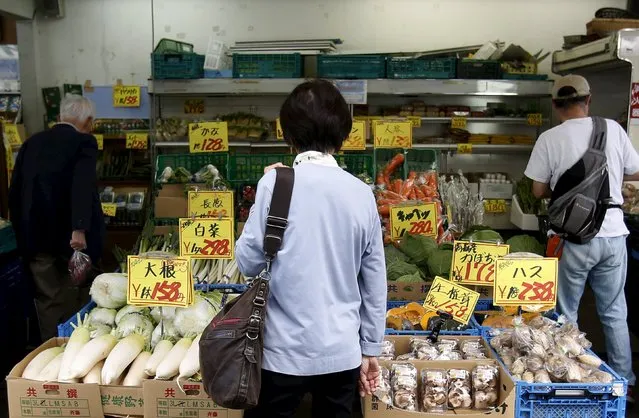 A woman looks at vegetables at a greengrocer at a shopping district in Kamakura, south of Tokyo, Japan, October 14, 2015. Japanese manufacturers' confidence worsened for the second straight month and is expected to fade going forward, a Reuters poll showed, adding to lingering fears of a recession and keeping policymakers under pressure to deploy fresh stimulus. (Photo by Yuya Shino/Reuters)