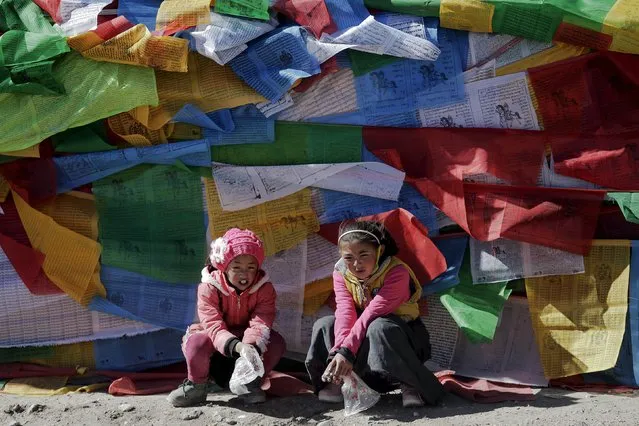 Tibetan girls sit in front of prayer flags at Namtso lake in the Tibet Autonomous Region, China November 18, 2015. (Photo by Damir Sagolj/Reuters)