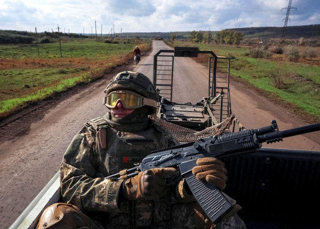 A serviceman of the 93rd Kholodnyi Yar Separate Mechanized Brigade of the Ukrainian Armed Forces looks up to check for Russian combat drones as he rides a pickup truck, amid Russia's attack on Ukraine, near the frontline city of Kostiantynivka in Donetsk region, Ukraine on October 22, 2025. (Photo by Anatolii Stepanov/Reuters)