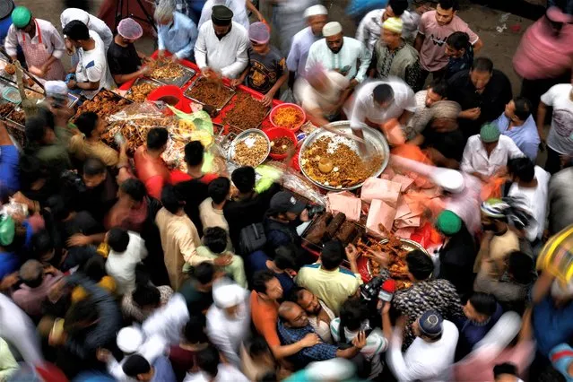 Muslims gather to buy food, on the first day of Ramadan, at Chawk Bazar's traditional makeshift Iftar market, in Dhaka, Bangladesh on March 24, 2023. (Photo by Mohammad Ponir Hossain/Reuters)