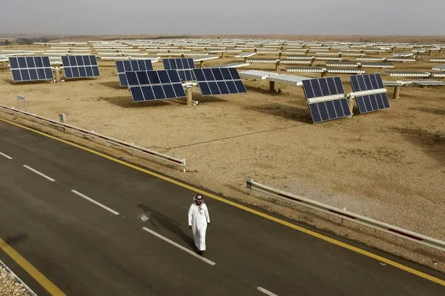 A Saudi man walks on a street past a field of solar panels at the King Abdulaziz city of Sciences and Technology, Al-Oyeynah Research Station in this May 21, 2012 file photo. (Photo by Fahad Shadeed/Reuters)