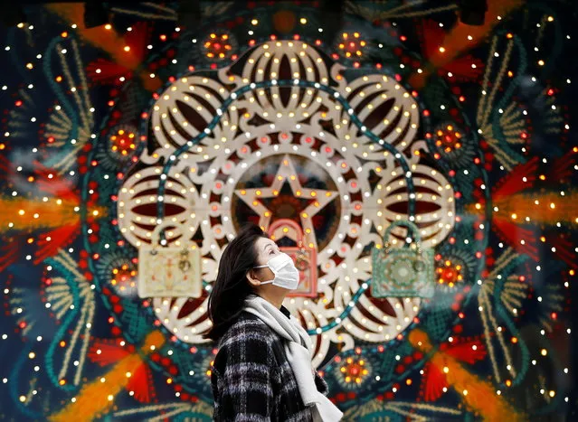 A woman wearing a protective face mask walks past Christmas decorations, amid the coronavirus disease (COVID-19) outbreak, at Ginza shopping district in Tokyo, Japan on December 19, 2020. (Photo by Issei Kato/Reuters)