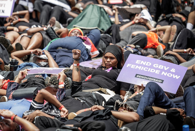 Protesters hold placards as they lie on the ground during the Women's Nationwide Shutdown at Constitution Hill in Johannesburg on November 21, 2025, ahead of the G20 leaders' Summit. Women for Change calls on the community across South Africa to refrain from all paid and unpaid work in workplaces, universities, and homes, and to spend no money for the entire day to demonstrate the economic and social impact of their absence, and demand that gender-based violence and femicide be declared a national disaster. (Photo by Gianluigi Guercia/AFP Photo)