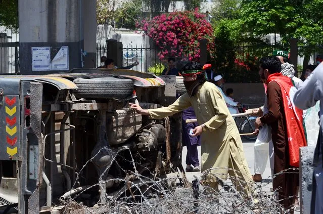 Clashes continue between Pakistani security forces and supporters of Pakistan Tehreek-e-Insaf (PTI) during a protest following former Prime Minister Imran Khan's arrest in Peshawar, Pakistan, on May 10, 2023. Police officers intervene the protestors using tear gas in the demonstration. (Photo by Hussain Ali/Anadolu Agency via Getty Images)