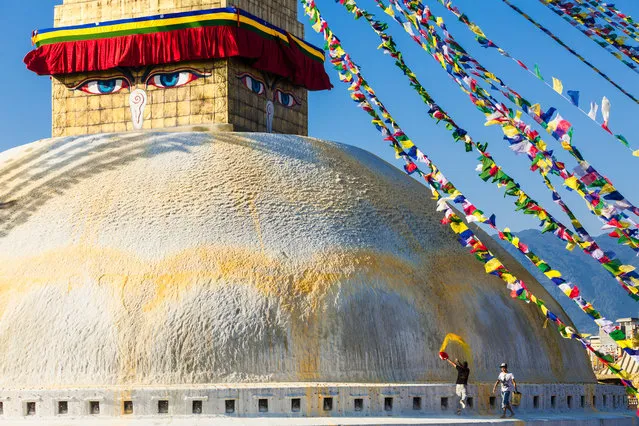 “Cleaning The Stupa”. Custodians fling yellow colored water made from saffron onto Bodhnath Stupa in Nepal. The yellow arc represents the double lotus. Bodhnath Stupa, located in the Kathmandu Valley, lies on the ancient trade route from Tibet and attracts thousands of pilgrims and tourists daily. (Photo and caption by Craig Ferguson/National Geographic Traveler Photo Contest)