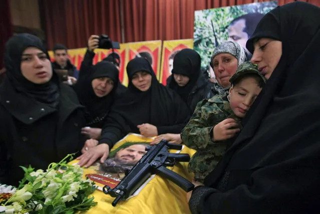 The sister of Hezbollah member Mohammad Issa who was killed in an Israeli airstrike in Syria on Sunday, holds his son Ahmed as she mourns over his coffin  during his funeral procession, in the southern village of Arab Salim, Lebanon, Tuesday, January 20, 2015. Hezbollah has accused Israel of carrying out Sunday's airstrike, which occurred on the Syrian side of the Golan Heights and killed six members of the Lebanese militant group and an Iranian general. (Photo by Mohammed Zaatari/AP Photo)