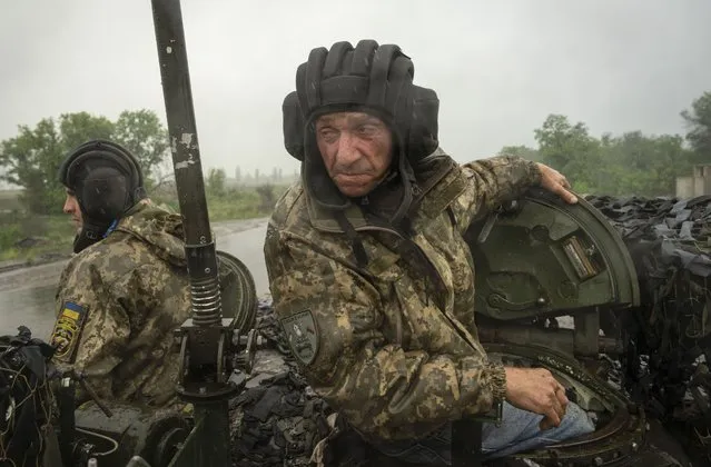 Ukrainian soldiers on a tank ride along the road towards their positions near Bakhmut, Donetsk region, Ukraine, Tuesday, May 23, 2023. (Photo by Efrem Lukatsky/AP Photo)